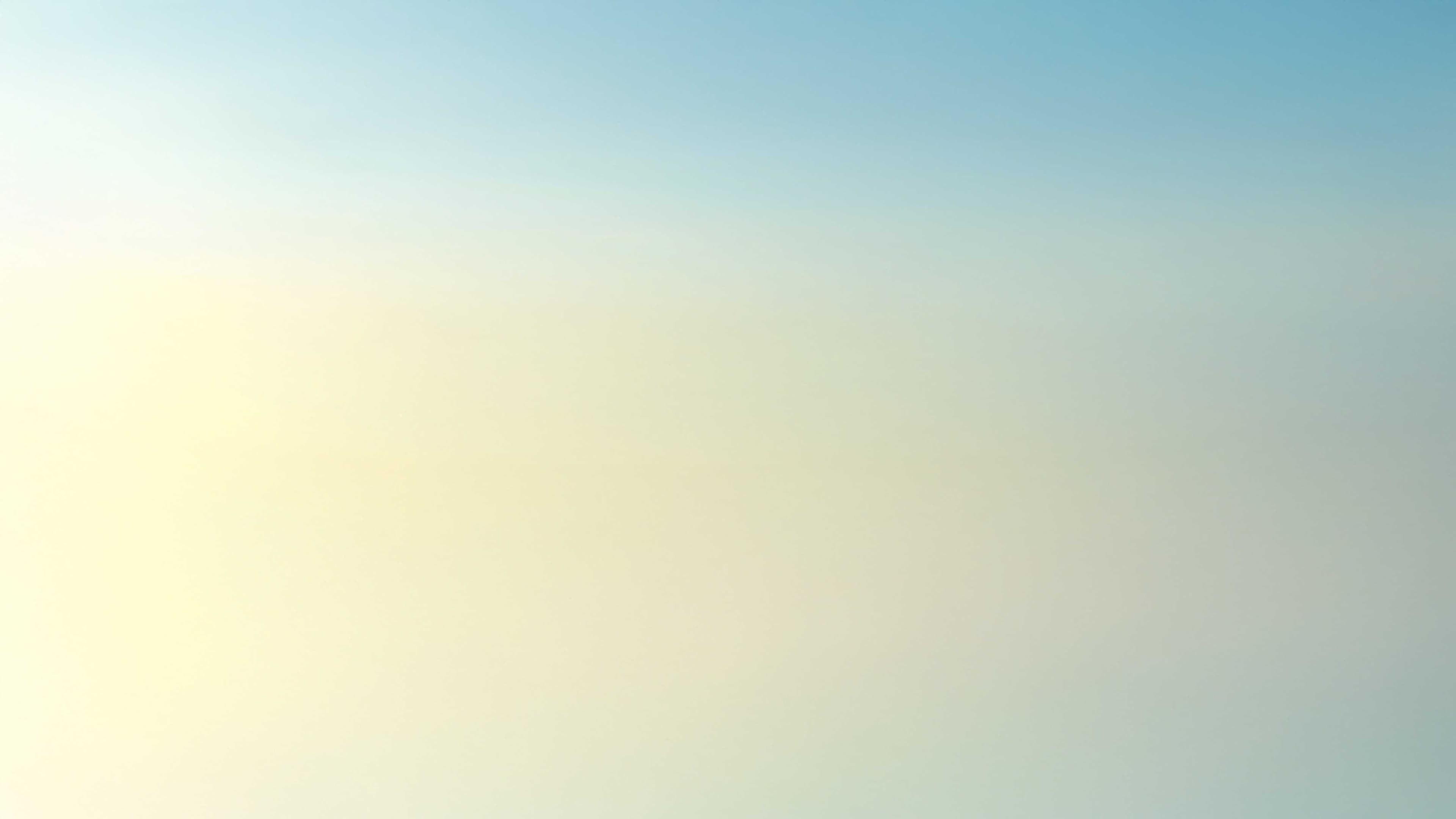 Soft gradient sky, transitioning from pale yellow to light blue.