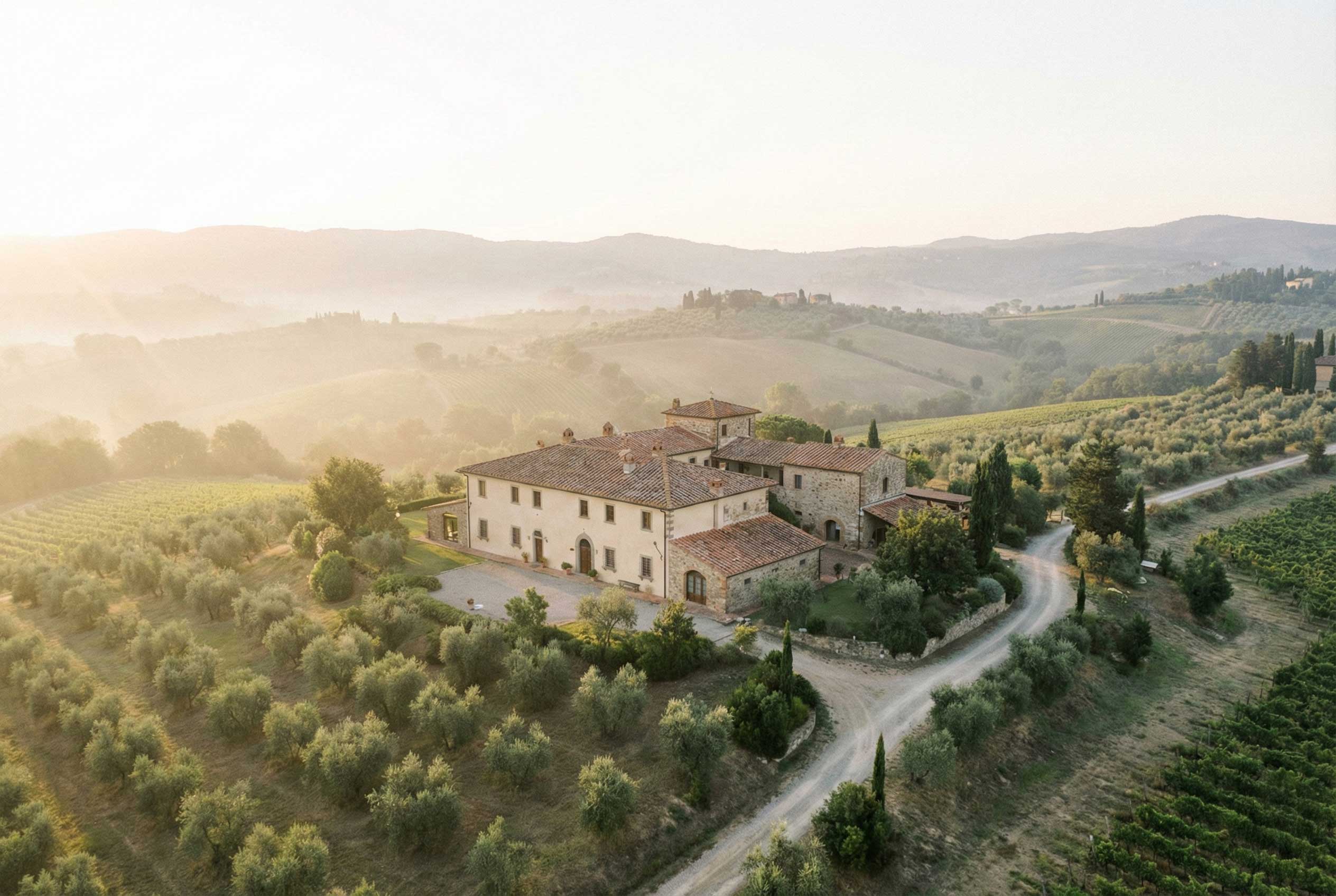 A stone farmhouse on a misty Tuscan hillside at dawn.